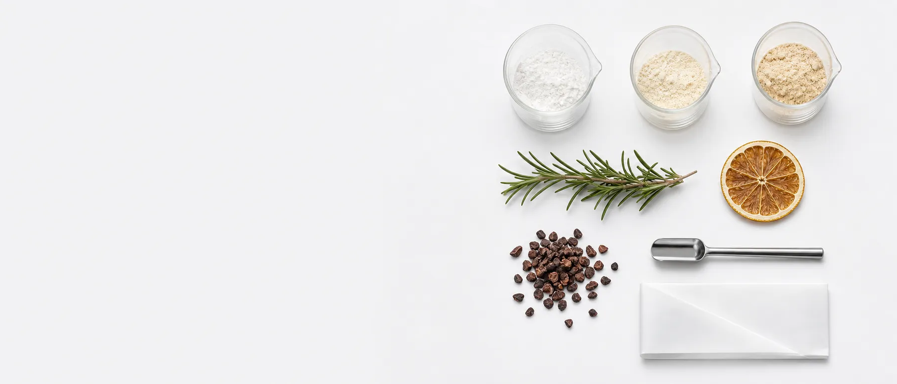 Formulation ingredients, powders, and a measuring scoop arranged on a white lab bench